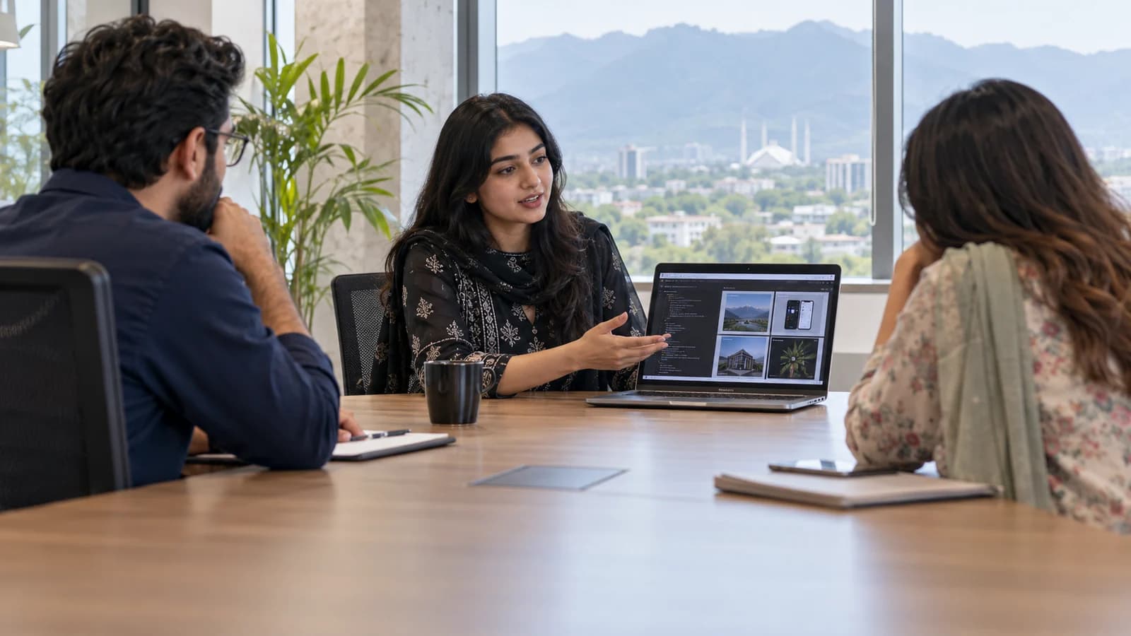 A Pakistani woman software developer in her mid twenties showing her portfolio on a laptop to two interviewers at a bright Islamabad technology office.